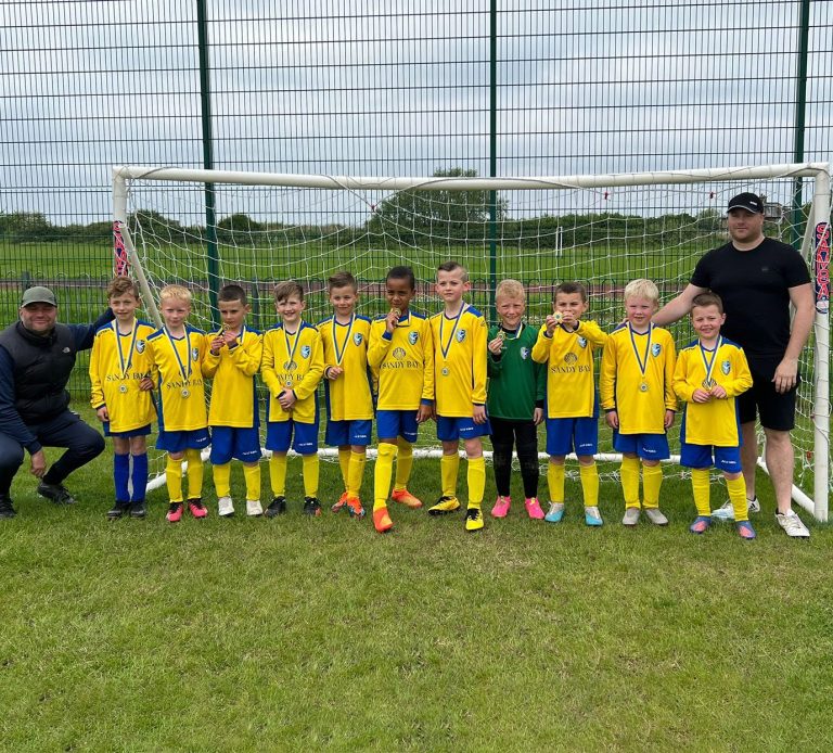 children in yellow and blue canvey island football kit in goal