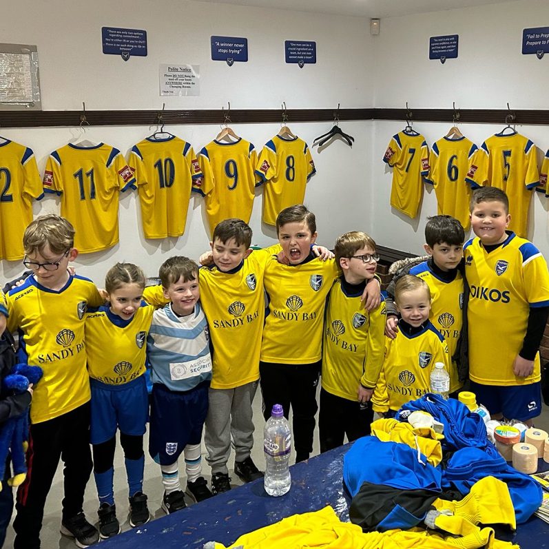 Young players infront of yellow team shirts